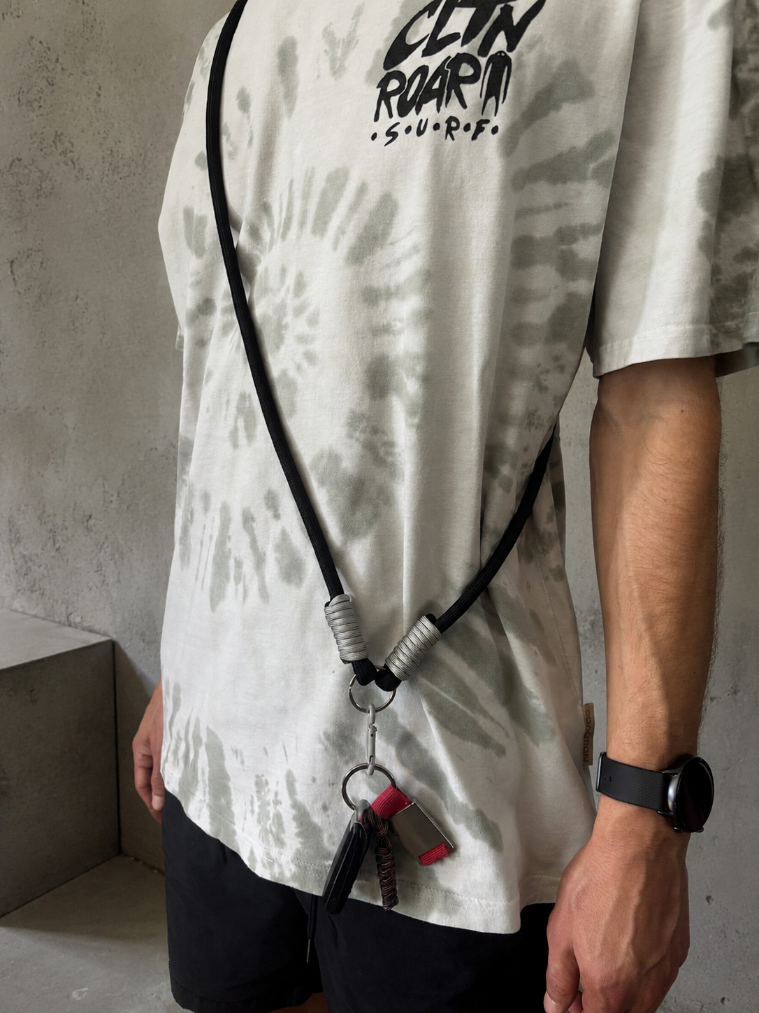 Czarny phone strap crossbody midnight rave noszony z przodu z przypiętymi kluczami